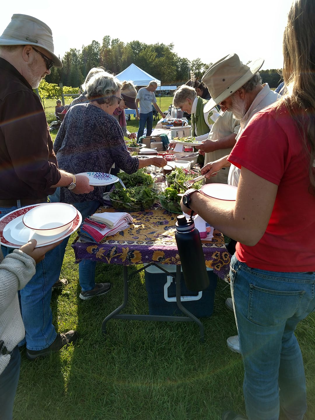 people gathered around a potluck table