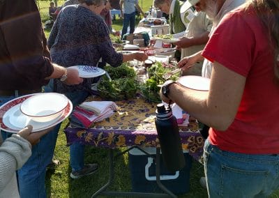 people gathered around a potluck table