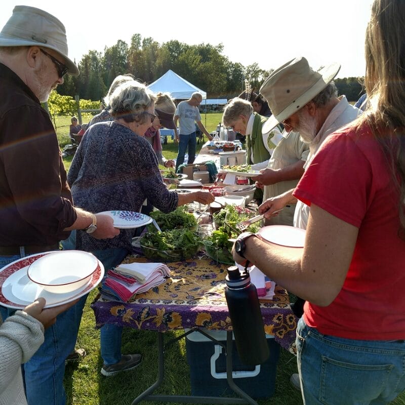 2 people gathered around a potluck table